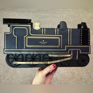 Kate Spade “All Aboard Train Clutch” purse.